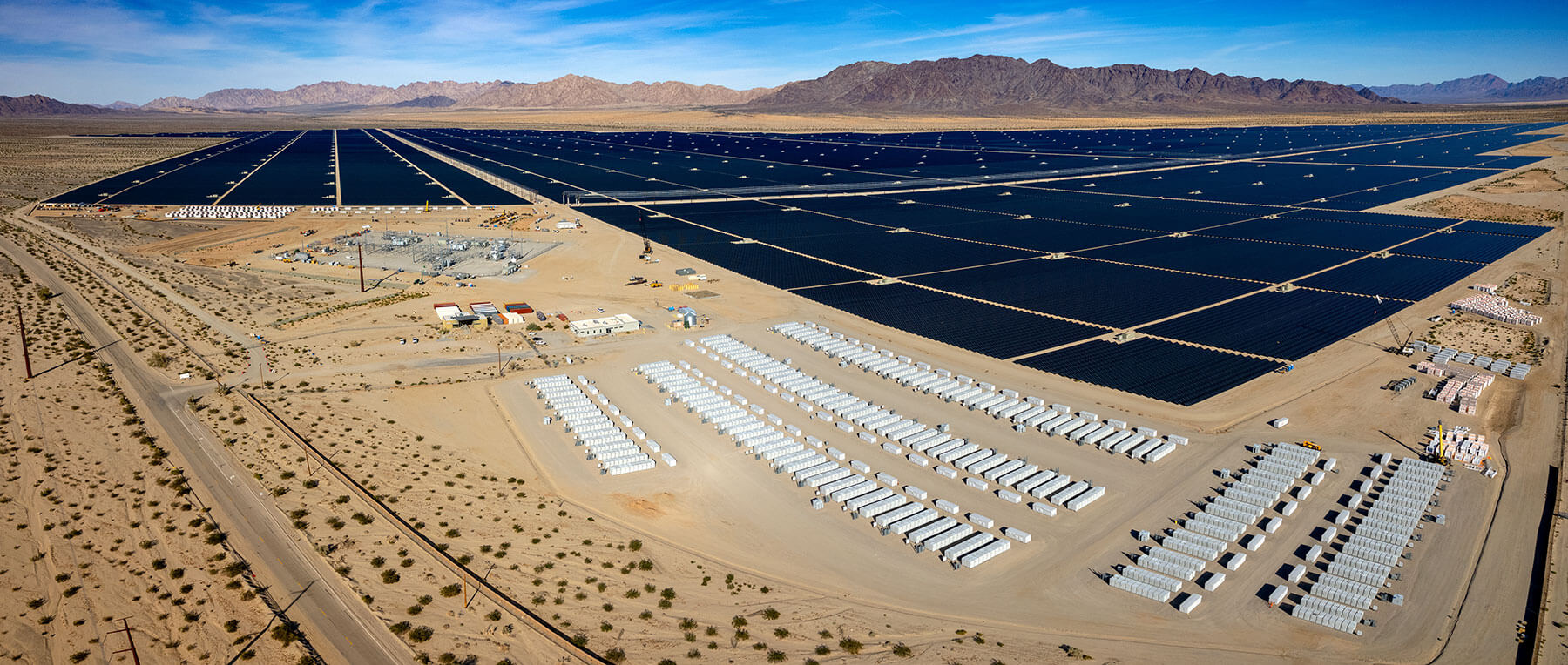 Aerial view of a large solar PV farm with battery energy storage units.